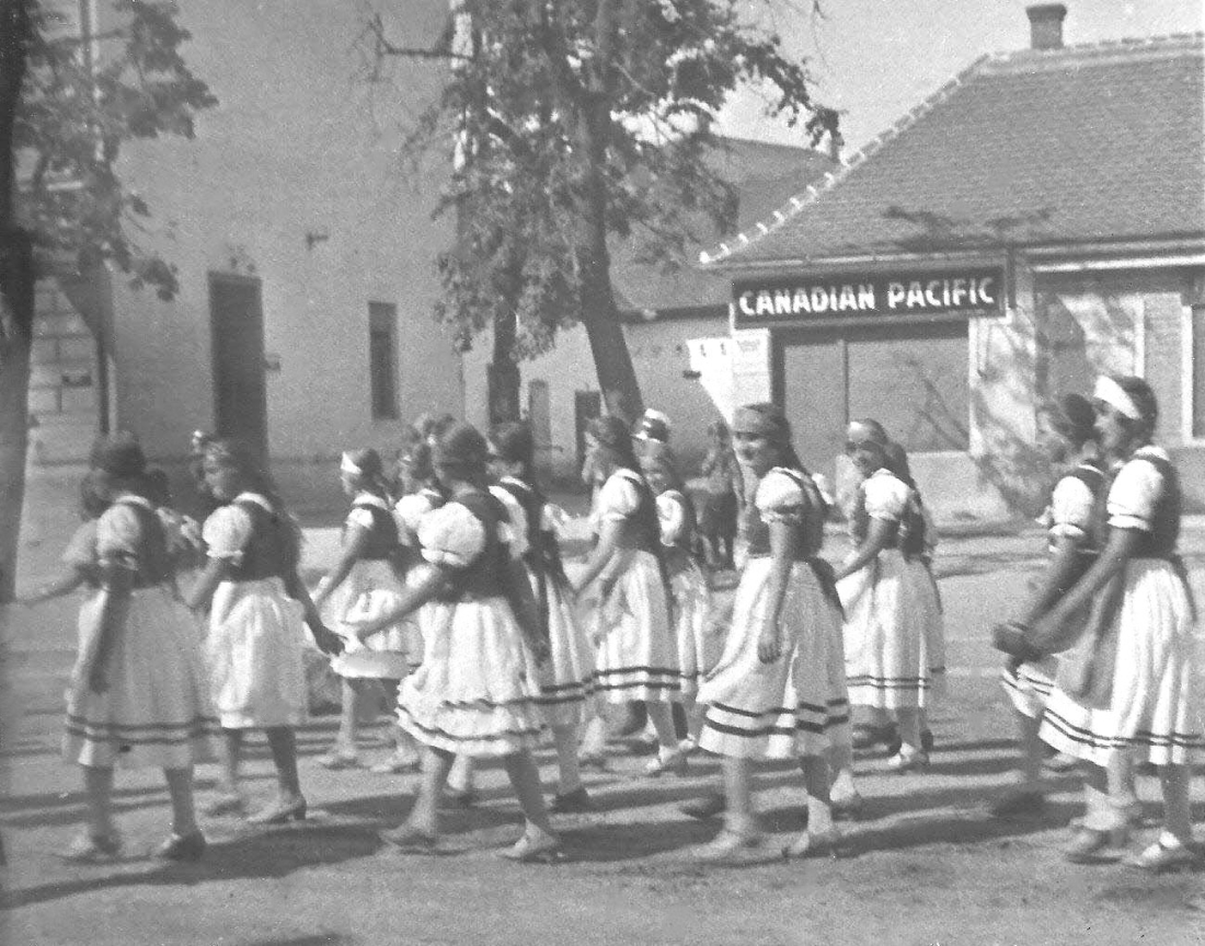 1. Feier zum Bestandsjubiläum - Gefeiert wurde der 40. Gründungstag des reformierten Lesevereins: Gruppe von jungen Mädchen in ungarischer Tracht - Festzug über den Hauptplatz vor dem Geschäftslokal von "Canadian Pacific" (OW 146a / Hauptplatz 5)