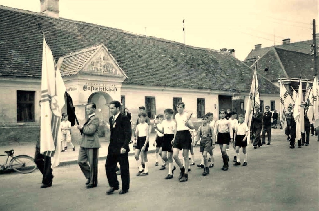 Festzug mit Fahnen der Kath. Jugend vor der Gastwirtschaft Johann Ruiter (Wienerstaße 1)