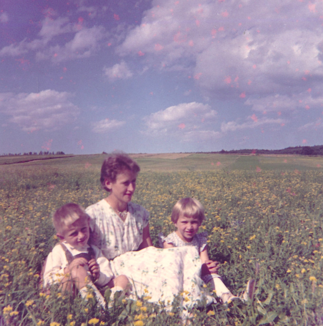 Mutter Margarethe Guger mit ihren Kindern Johann und Anna Maria in einer Wiese nahe des Zickenbaches