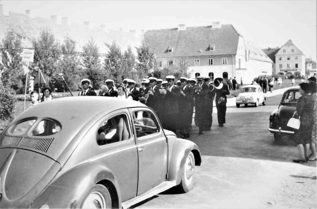 Stadtkapelle: Marschformation in der Wienerstraße, im Vordergrund ein VW Käfer "Brezelkäfer"