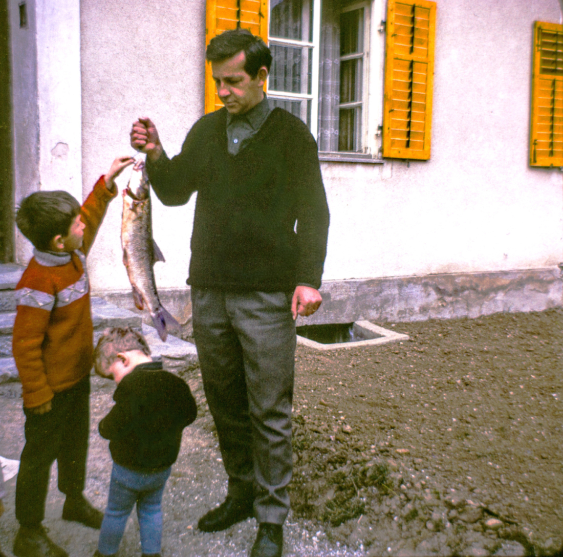 Der passionierte Fischer Herbert Unger präsentiert seinen Söhnen eine schöne Forelle - Andreas Hofer Siedlung