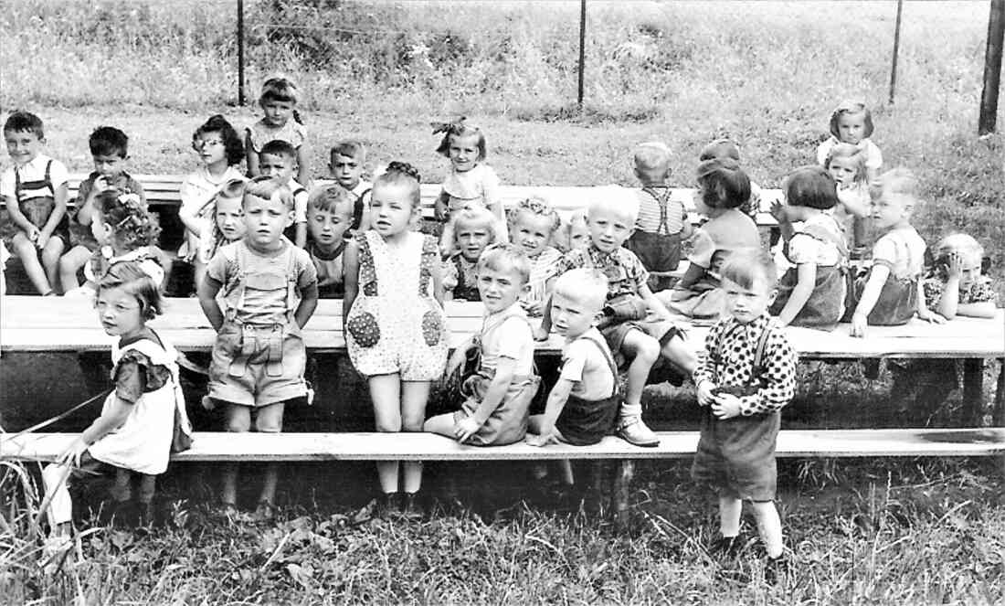 Städtischer Kindergarten: Kinder im Garten an den Tischen