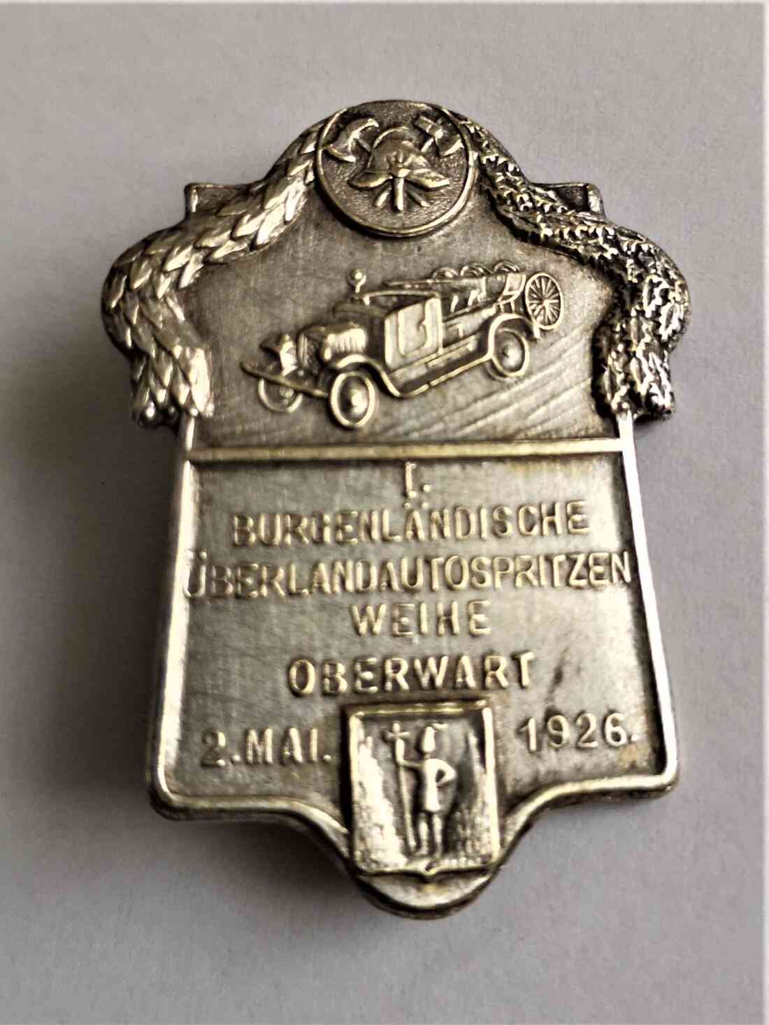 Freiwillige Feuerwehr: Anstecker anlässlich der Ankunftsfeier des ersten Feuerwehrautos "Überland Automotorspritze" Mai 1926