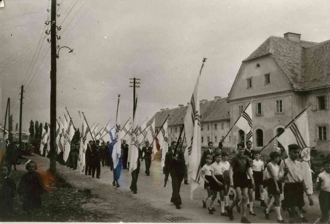 Festzug mit Fahnen der Kath. Jugend vor der Südtiroler Siedlung (Wienerstaße 28)