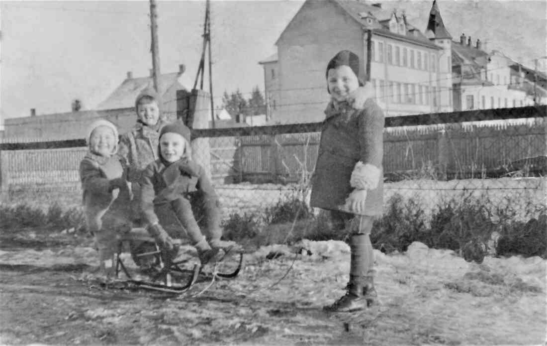 Die Geschwister Otto und Anna Benedek mit Freunden beim Schlittenfahren mit Blick auf die Häuser Wienerstraße 16 und 18