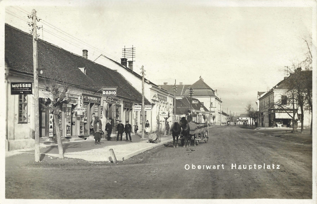 Ansichtskarte: Hauptplatz mit Blick in die Wienerstraße - Musser/Angelus/Stehlik/Fischer/Varga/Gorell/Freislinger/ Schlenger/Schmidt/Löwy