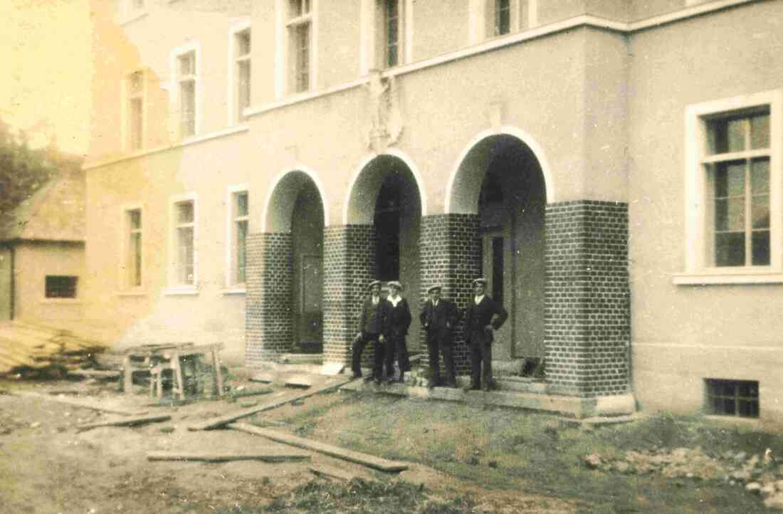 Vier Männer posieren vor der im Bau befindlichen Kaserne (Prinz Eugenstraße 6)