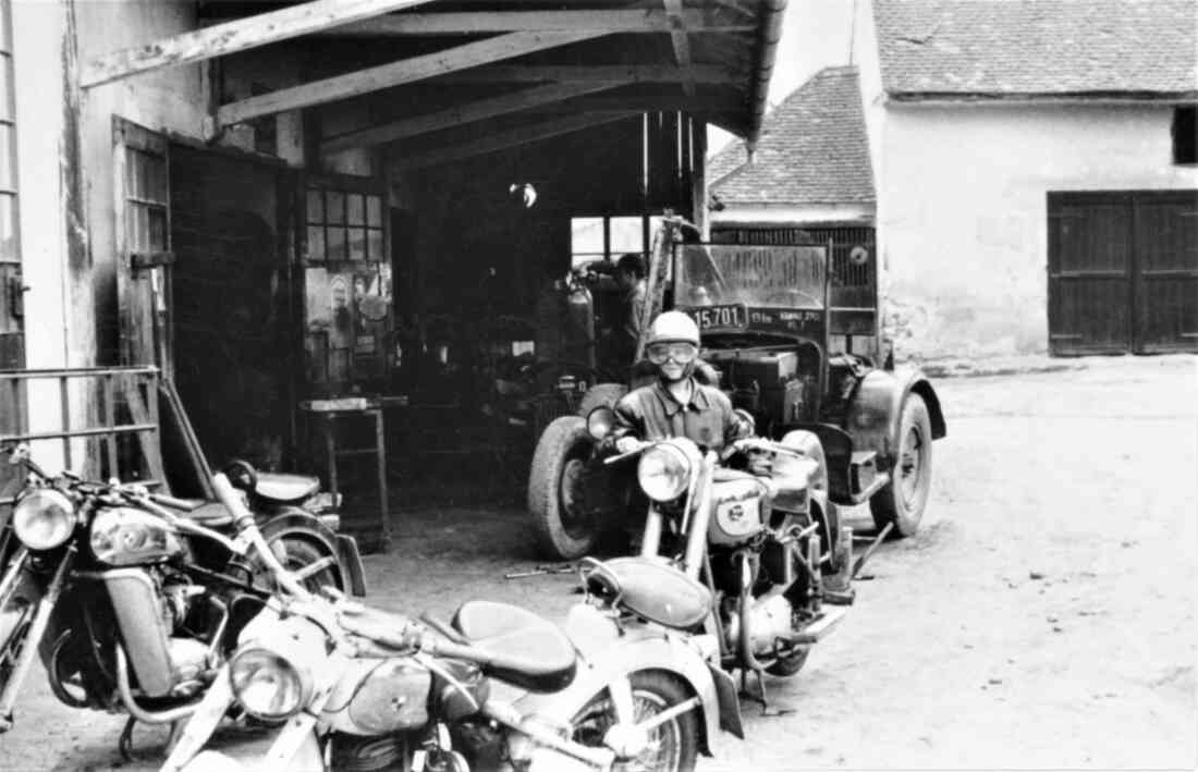 Reparaturwerkstätte Palank: Rainer Palank und der Blick auf die Motorräder vor dem Betriebsgebäude gegen NW