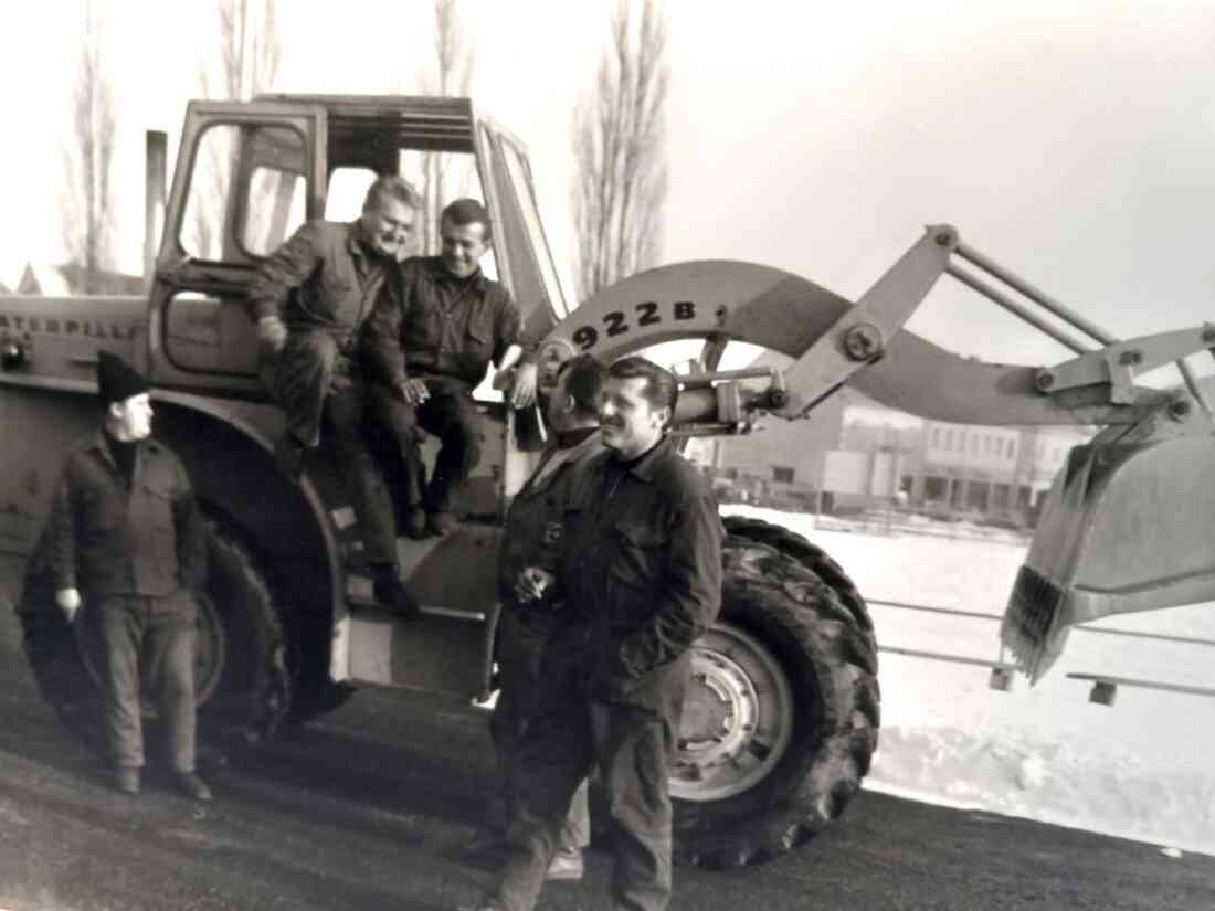 Bauamt/Straßenbaubezirksamt: Gruppe von Mitarbeitern vor einem Baggerlader der Marke Caterpillar (Seper/Wagner/Benedek/Ritter)