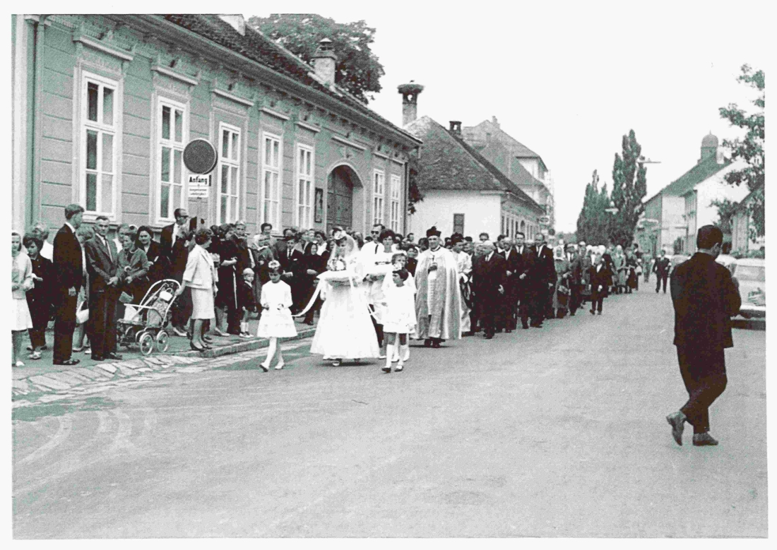 Röm. kath. Pfarre: Primiz von Julius Dirnbeck: der festliche Zug auf dem Weg vom Hauptplatz zur Kirche vor dem Haus Steinamangererstraße 10 (früher in jüdischem Besitz)